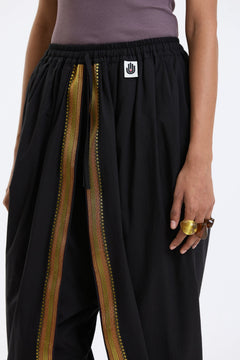 Cotton Dhoti Pants with Zari Border – Black & Gold by Swasthii, worn by a model – view 3